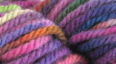 Northern Lights: hand dyed, bulky rug weight, 100% wool spot dyed yarn in a dark background with pink and green highlights colors for rug hooking and punching.